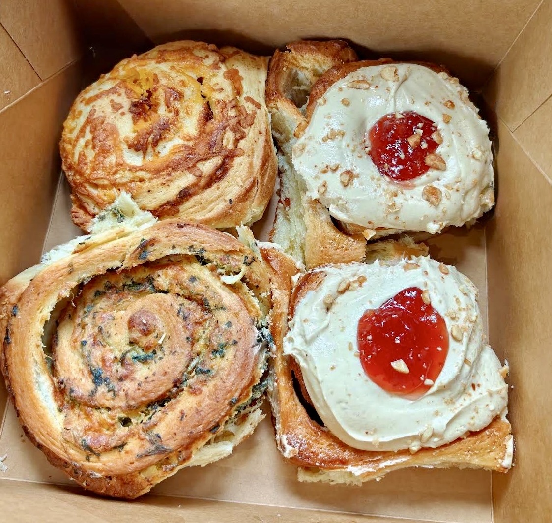 A bakery box with an assortment of sweet and savory Sugar Street Buns